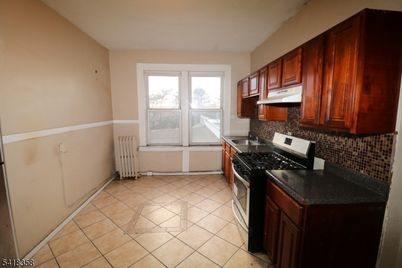 413 Lyons Avenue, Unit 2L Newark, NJ 07112 - Photo 12 of 15 a kitchen with a stove a sink and a cabinet