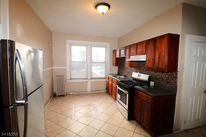 413 Lyons Avenue, Unit 2L Newark, NJ 07112 - Photo 2 of 15 a kitchen with stainless steel appliances granite countertop a refrigerator stove and sink