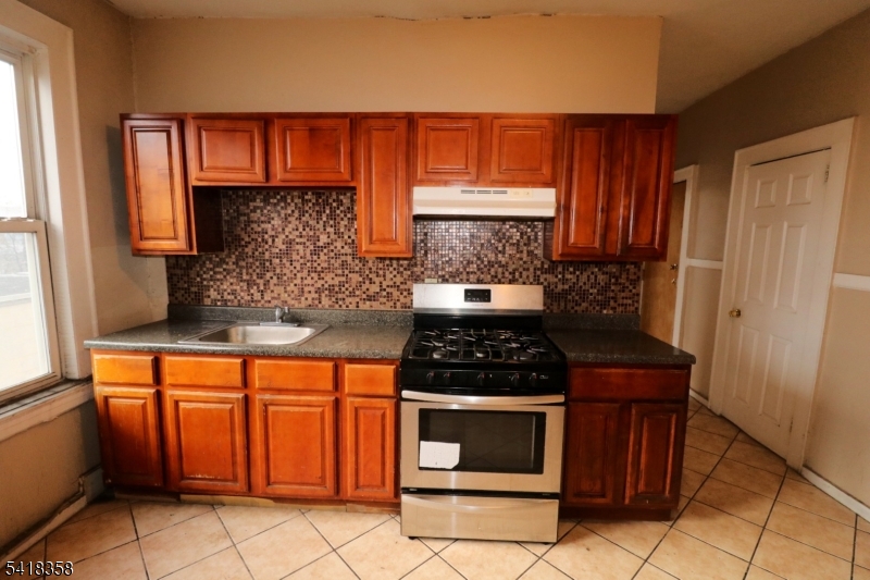 413 Lyons Avenue, Unit 2L Newark, NJ 07112 - Photo 3 of 15 a kitchen with stainless steel appliances granite countertop a stove a sink and a microwave
