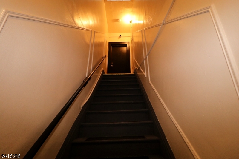 413 Lyons Avenue, Unit 2L Newark, NJ 07112 - Photo 7 of 15 a view of a hallway with wooden floor and stairs