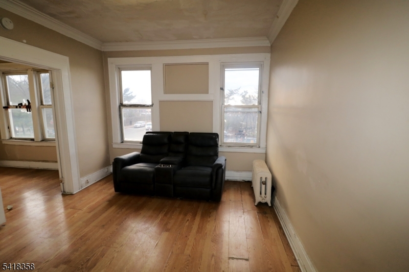 413 Lyons Avenue, Unit 2L Newark, NJ 07112 - Photo 9 of 15 a living room with furniture and a wooden floor