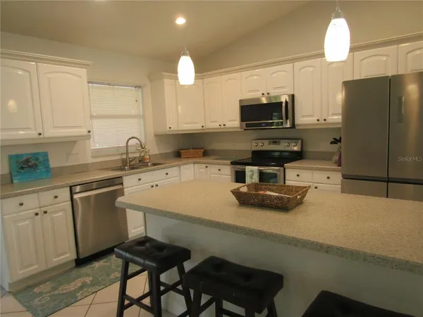 a kitchen with a sink a microwave a stove and refrigerator