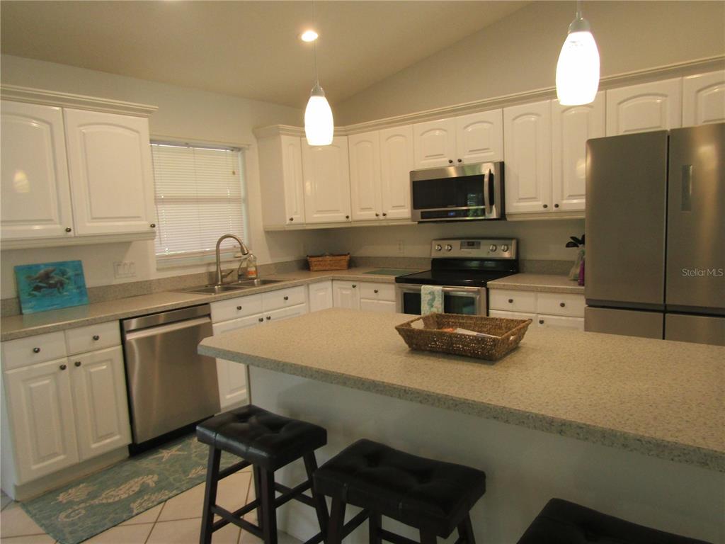 142 Solana Street North Port, FL 34287 - Photo 6 of 17 a kitchen with a sink a microwave a stove and refrigerator