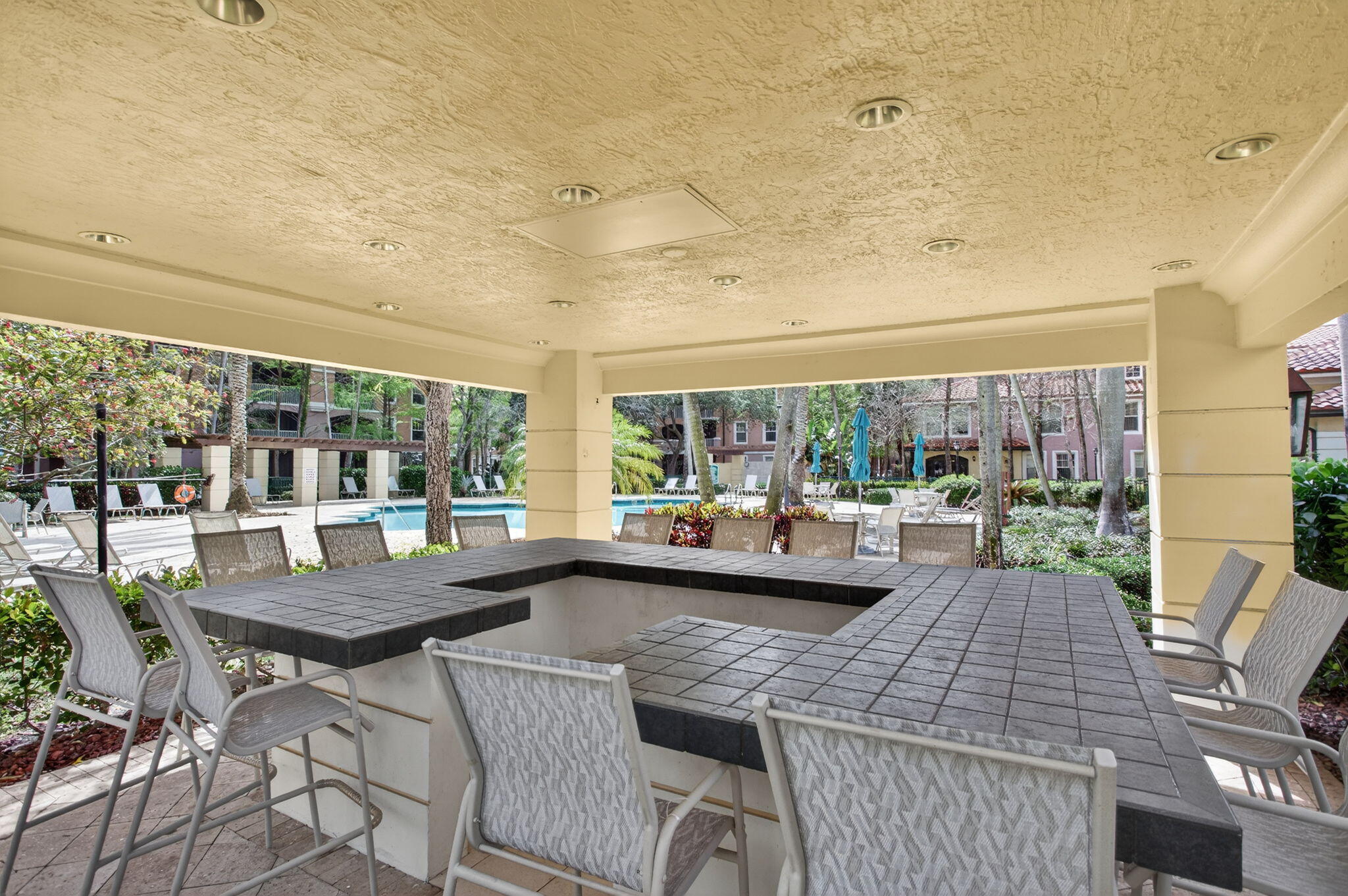 6890 West Sample Road, Unit 6890 Pompano Beach, FL 33063 - Photo 23 of 36 a view of a dining room with furniture large windows and wooden floor