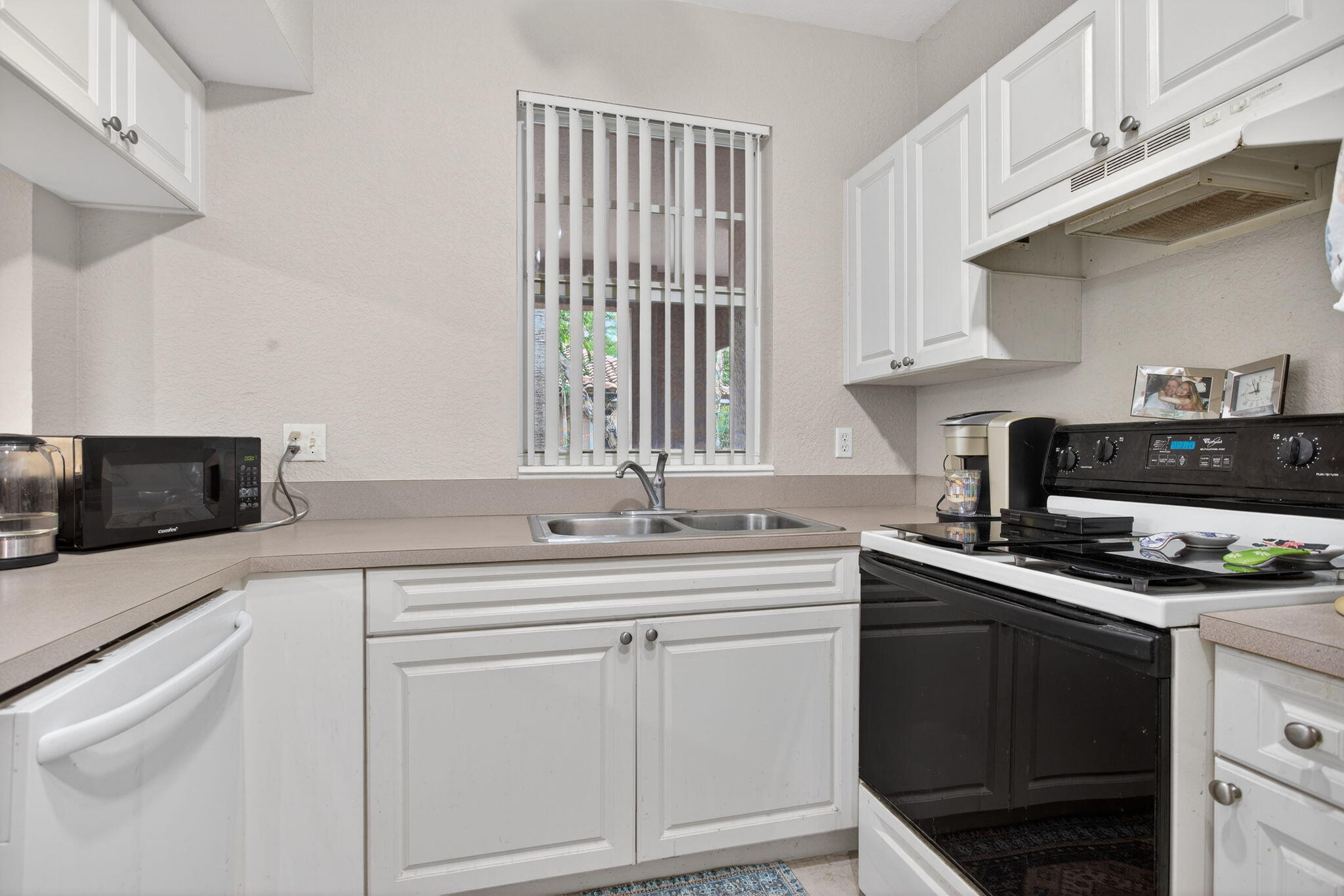 6890 West Sample Road, Unit 6890 Pompano Beach, FL 33063 - Photo 8 of 36 a kitchen with stainless steel appliances a sink stove and cabinets