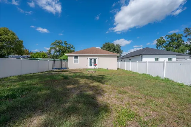a view of a house with a big yard plants and large tree