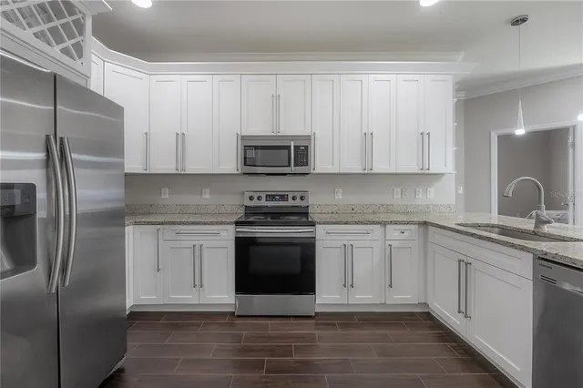 a kitchen with stainless steel appliances granite countertop a stove a sink and a microwave