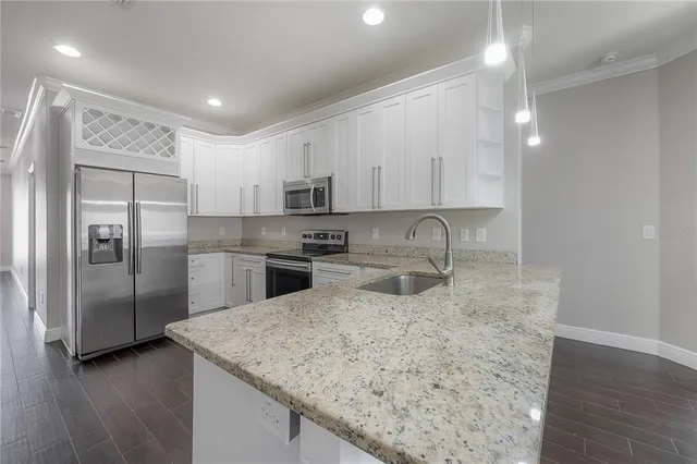 a kitchen with stainless steel appliances granite countertop a sink refrigerator and microwave