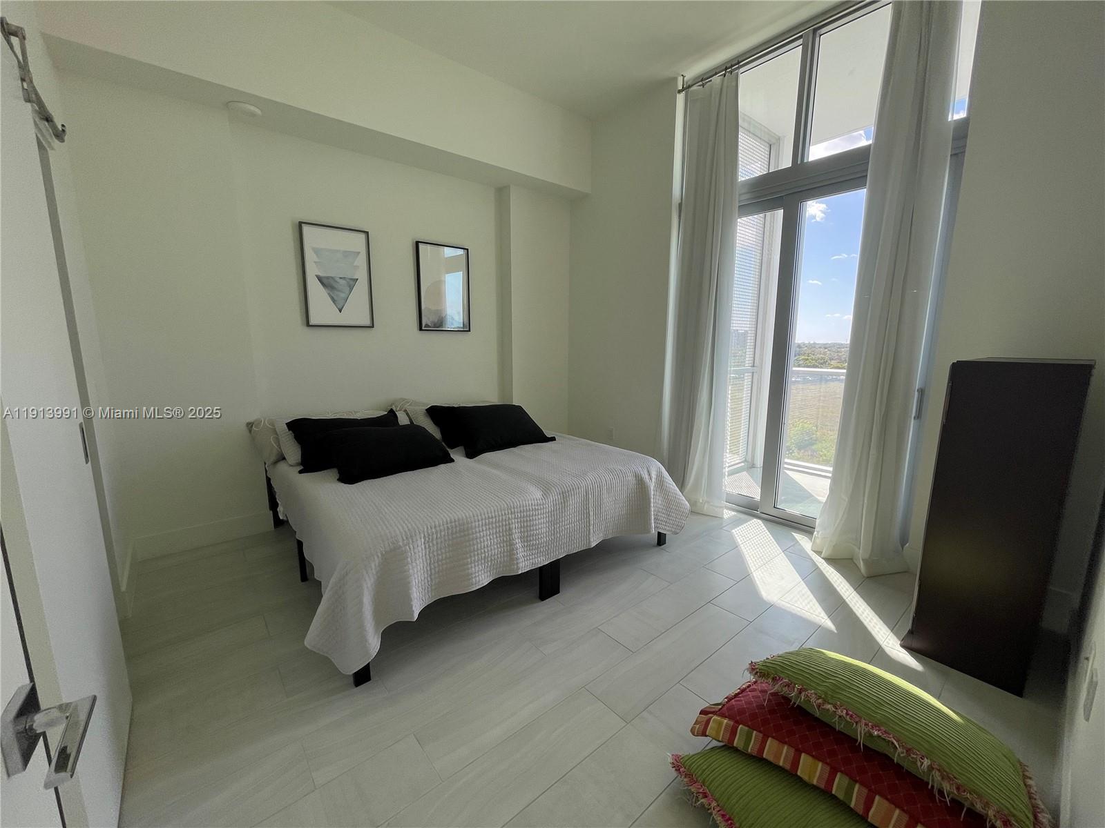 2000 Metropica Way, Unit 605 Sunrise, FL 33323 - Photo 24 of 24 a bedroom with a bed and a window