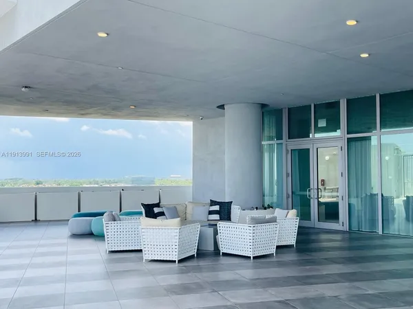 a gym room with lots of furniture and a chandelier
