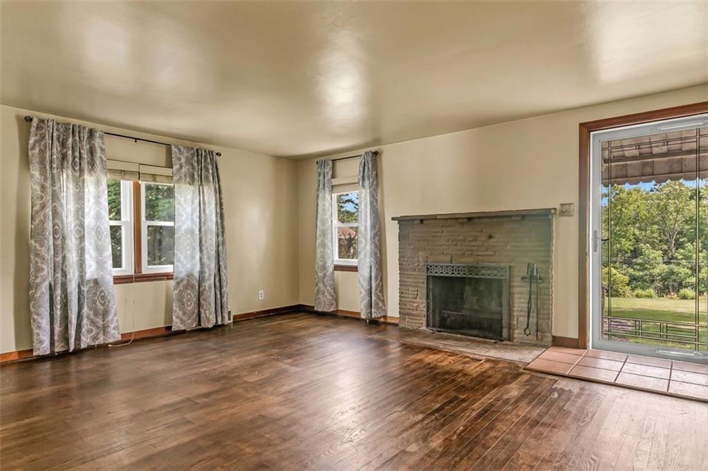 575 State Rte 908 Extension Tarentum, PA 15084 - Photo 5 of 32 an empty room with wooden floor fireplace and windows