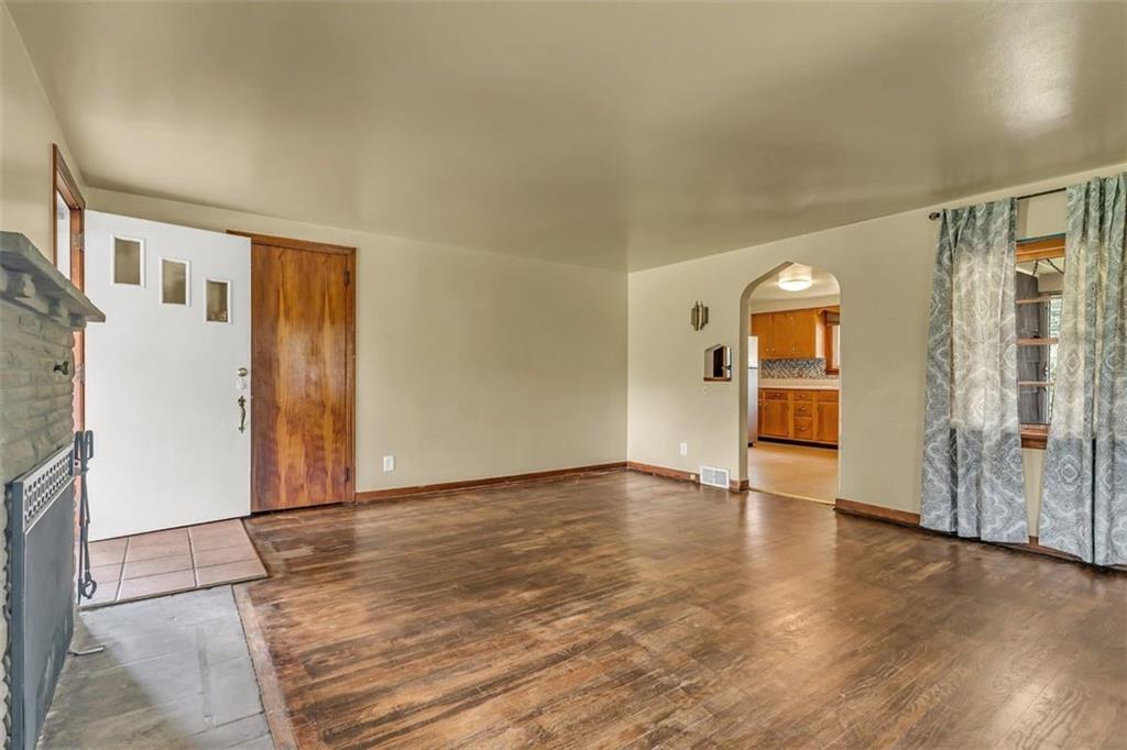 575 State Rte 908 Extension Tarentum, PA 15084 - Photo 6 of 32 an empty room with wooden floor and a kitchen