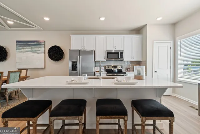 a kitchen with a dining table chairs and a refrigerator
