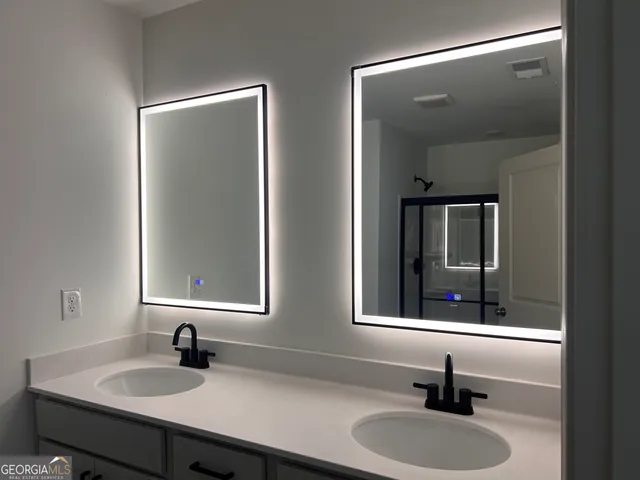 a bathroom with double vanity sinks and a mirror