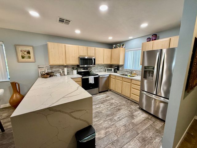 a kitchen with stainless steel appliances a refrigerator stove microwave and sink