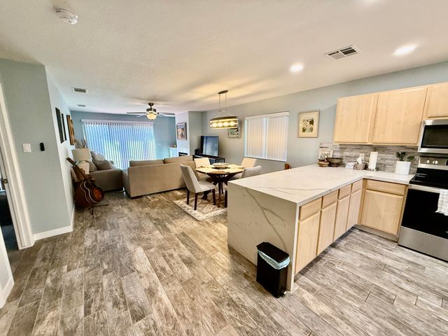 a view of kitchen with refrigerator stove and wooden cabinets