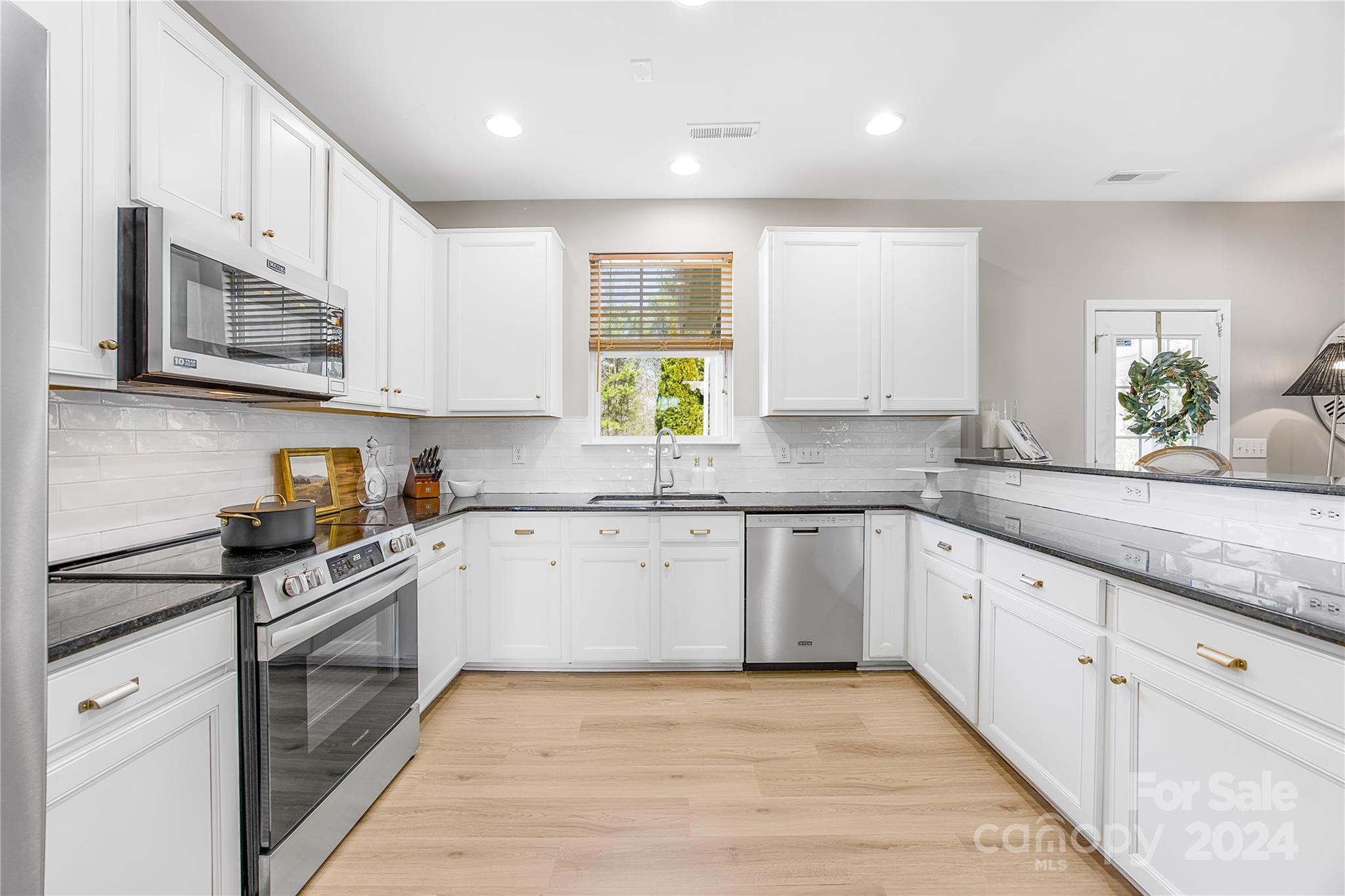 1003 Sipes Place Indian Trail, NC 28079 - Photo 21 of 45 a kitchen with stainless steel appliances granite countertop a stove sink and cabinets