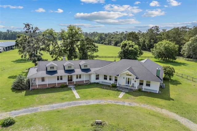 a aerial view of a house with swimming pool and large trees