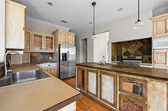 a kitchen with stainless steel appliances granite countertop a sink a stove and a refrigerator