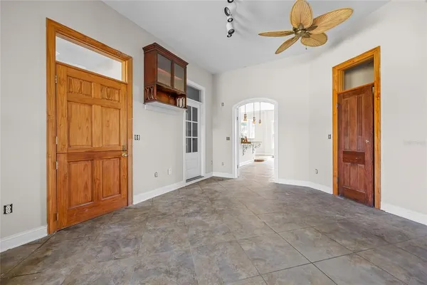 a view of a hallway with a cabinet and a chandelier fan