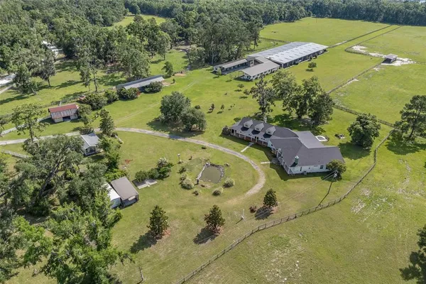 an aerial view of a house with a yard and swimming pool