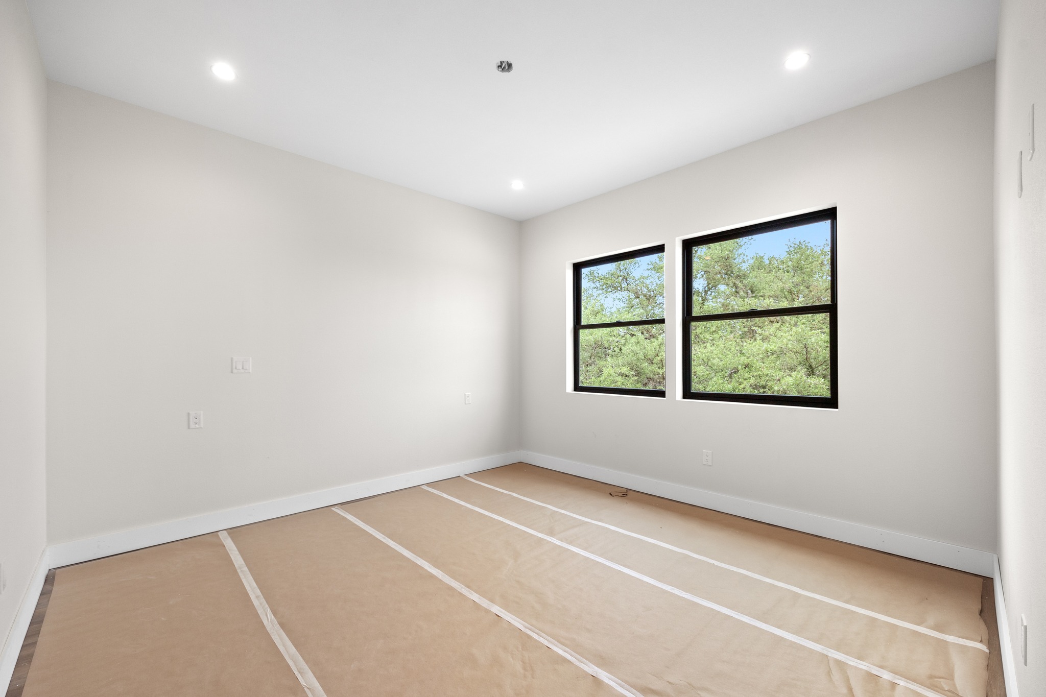 903 Flint Ridge Trail Georgetown, TX 78628 - Photo 32 of 39 Recessed lighting illuminates this bright room featuring two windows with black frames and white baseboards