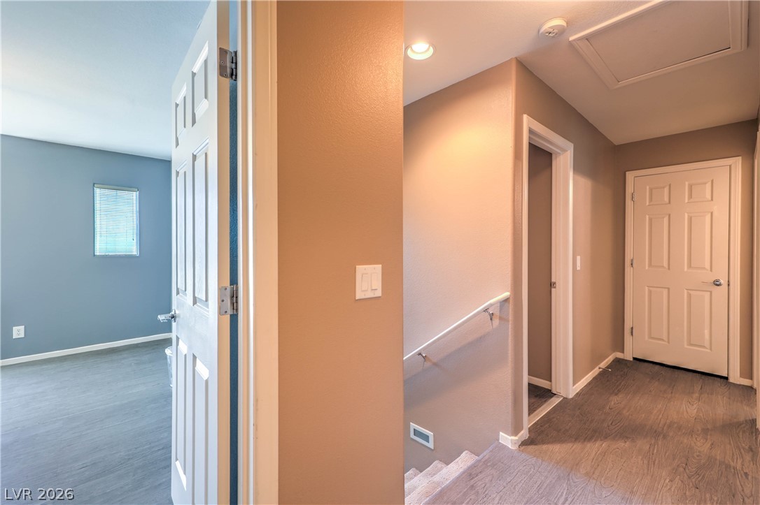9068 West Alluring Avenue Las Vegas, NV 89149 - Photo 12 of 23 This interior hallway features a staircase, providing access to multiple levels within the residence.