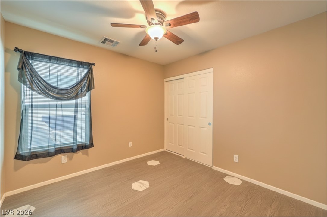 9068 West Alluring Avenue Las Vegas, NV 89149 - Photo 16 of 23 This inviting bedroom features neutral tones, a window with blinds, and durable laminate flooring.
