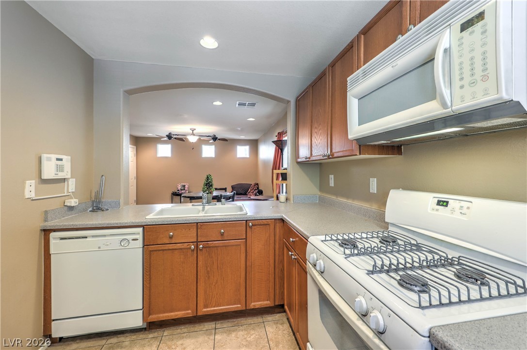 9068 West Alluring Avenue Las Vegas, NV 89149 - Photo 7 of 23 This functional kitchen provides a seamless connection to the living area, creating an inviting atmosphere.