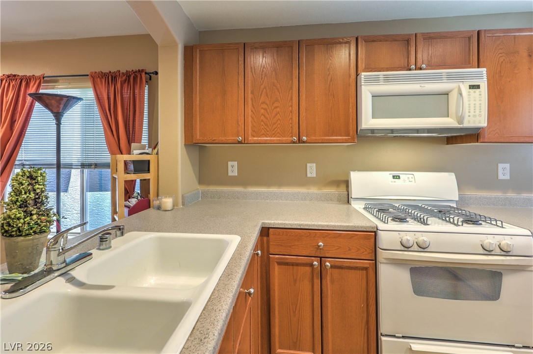 9068 West Alluring Avenue Las Vegas, NV 89149 - Photo 8 of 23 This functional kitchen features a window over the sink and ample cabinetry.