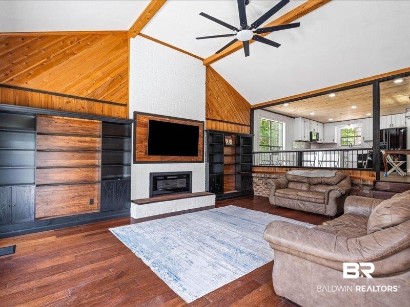 3160 Old Castleberry Road Brewton, AL 36426 - Photo 5 of 36 Spacious living area featuring high vaulted ceilings with wood beams, dark wood-finish flooring, and a contemporary ceiling fan