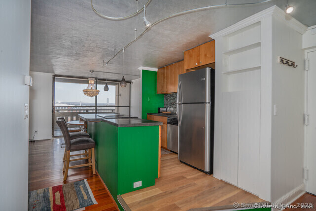1 Gold Street, Unit 11E Hartford, CT 06103 - Photo 11 of 25 a kitchen with a refrigerator and a table