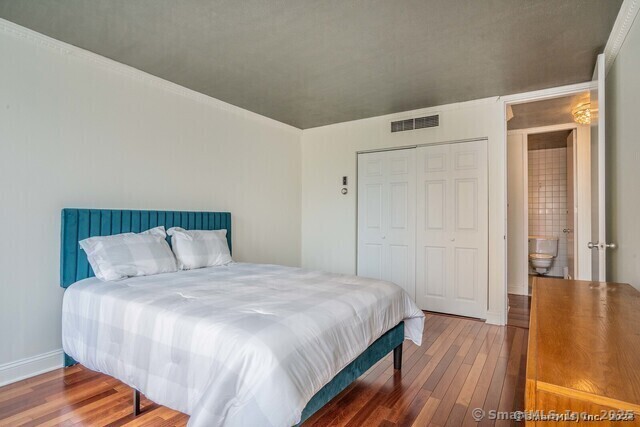 1 Gold Street, Unit 11E Hartford, CT 06103 - Photo 18 of 25 a bedroom with a bed and wooden floor