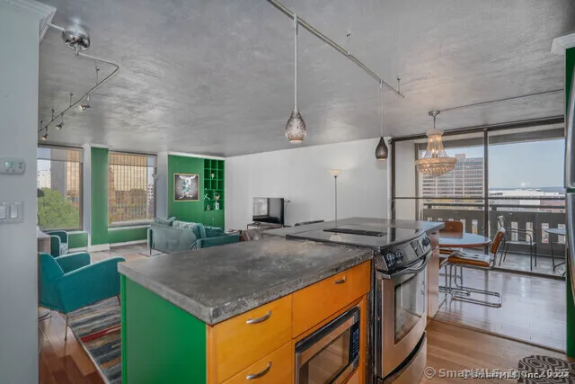 a open kitchen with stainless steel appliances granite countertop a stove and a refrigerator