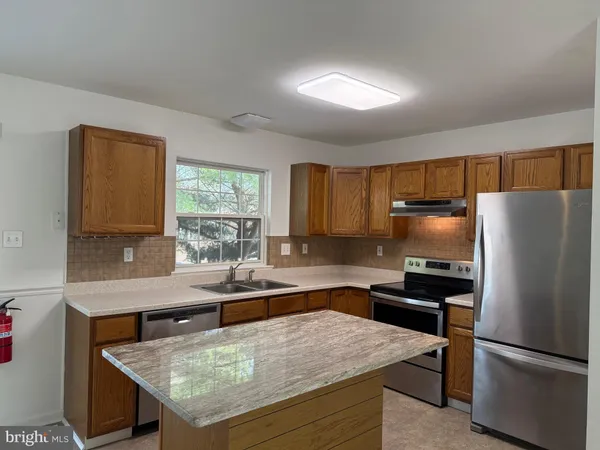 a kitchen with stainless steel appliances granite countertop a sink refrigerator and microwave