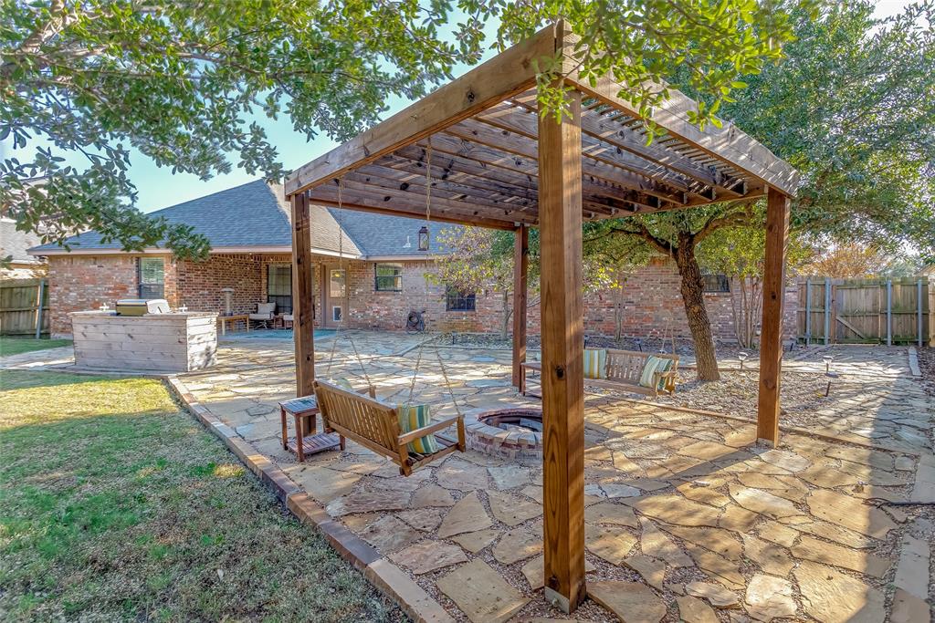 226 King George Road Ponder, TX 76259 - Photo 11 of 39 Fenced backyard with a patio area, a pergola, and an outdoor kitchen