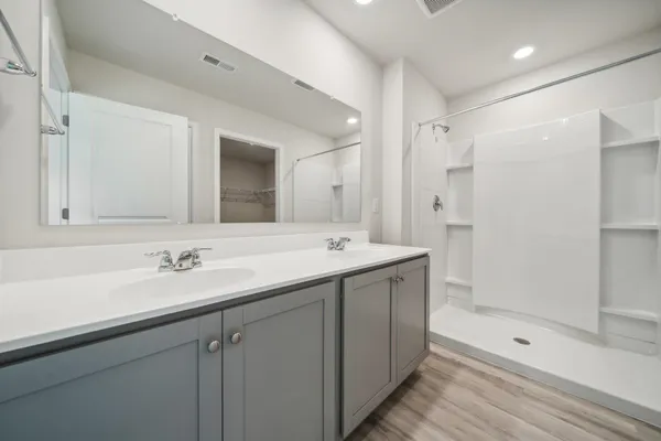 a bathroom with a shower sink and mirror