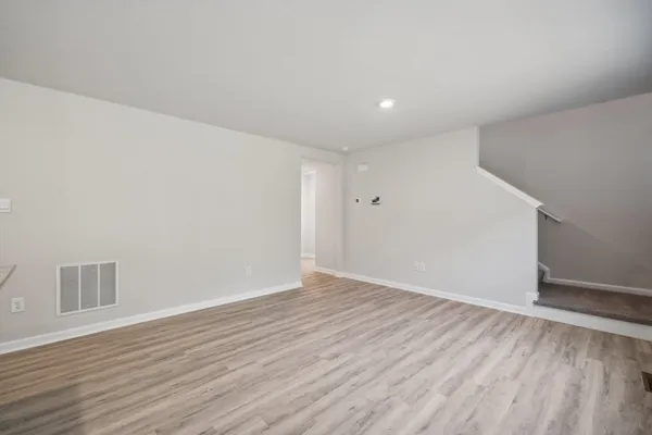 a view of an empty room with wooden floor