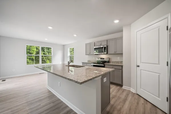 a kitchen with stainless steel appliances granite countertop a sink stove and refrigerator