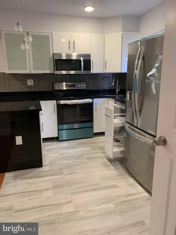 a kitchen with a refrigerator and a stove top oven