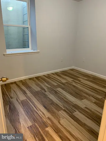 a view of a room with wooden floor and a window