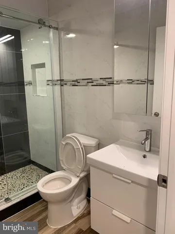 a bathroom with a sink a toilet and shower