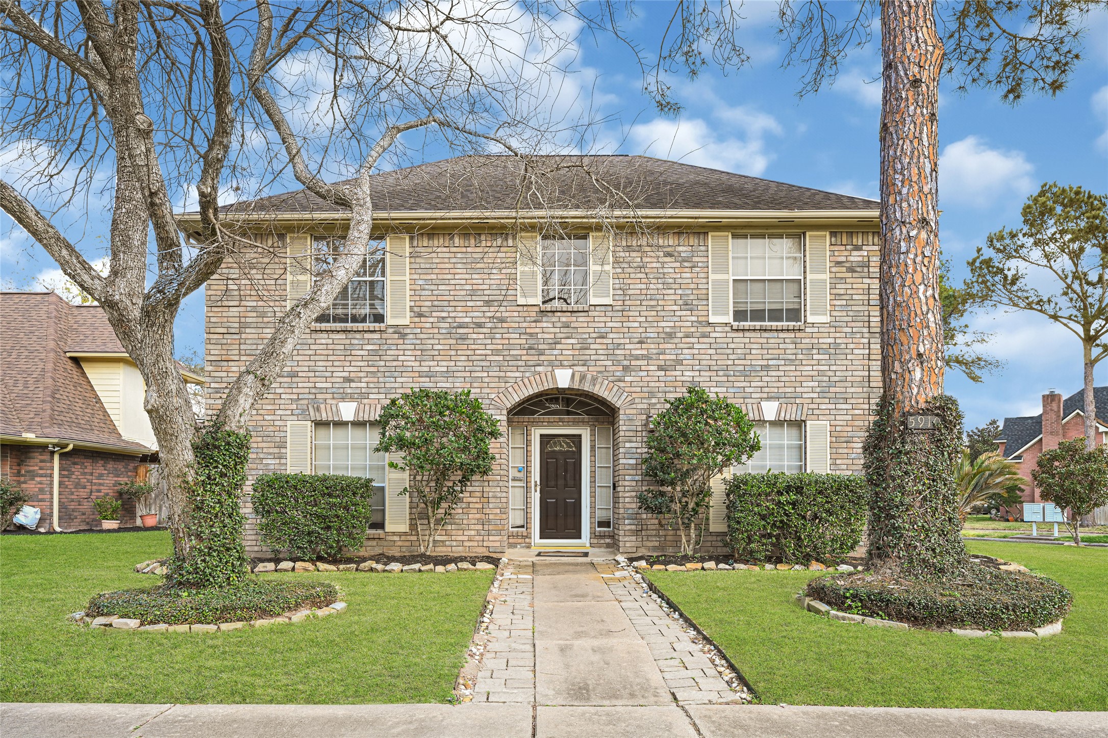 5910 Rolff Lane Houston, TX 77084 - Photo 1 of 50 Elegant two-story brick home featuring mature trees, manicured landscaping, and impressive curb appeal.