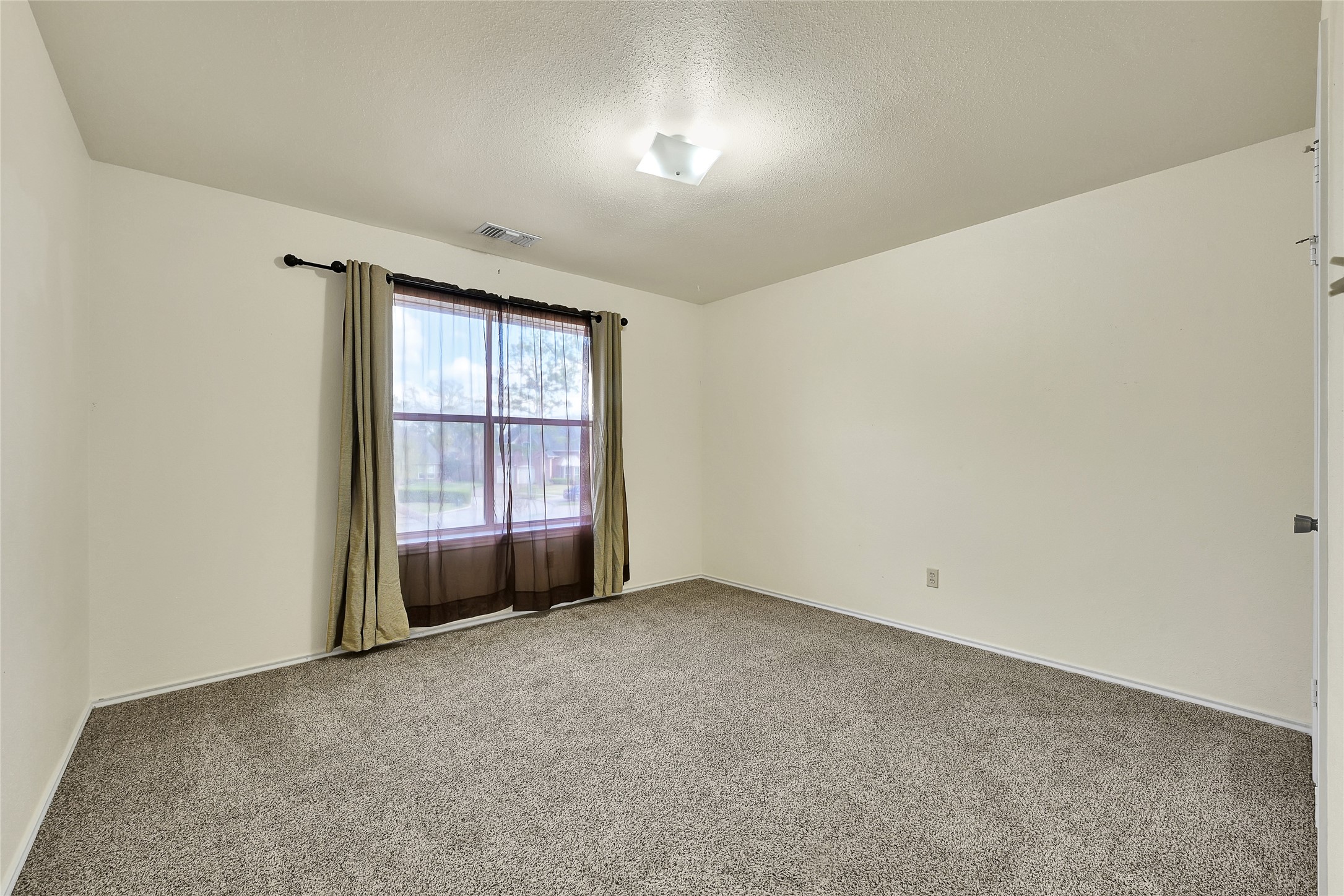 5910 Rolff Lane Houston, TX 77084 - Photo 15 of 50 Spacious bedroom with neutral tones, large window, and comfortable layout.
