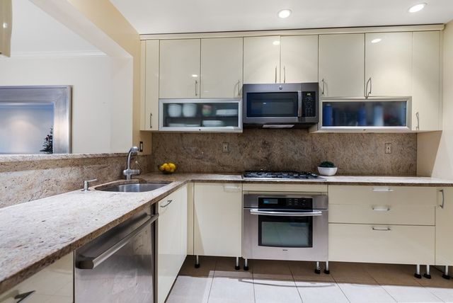 a kitchen with stainless steel appliances granite countertop a sink and a stove