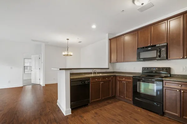a kitchen with stainless steel appliances granite countertop a stove a sink and a microwave