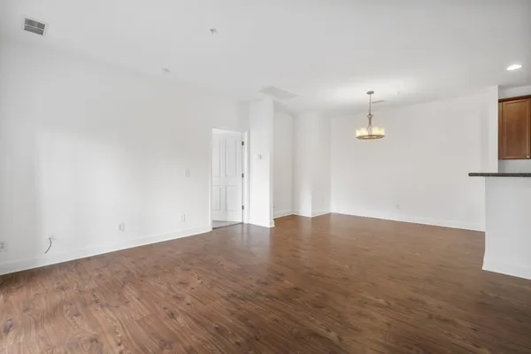 an empty room with wooden floor and sink