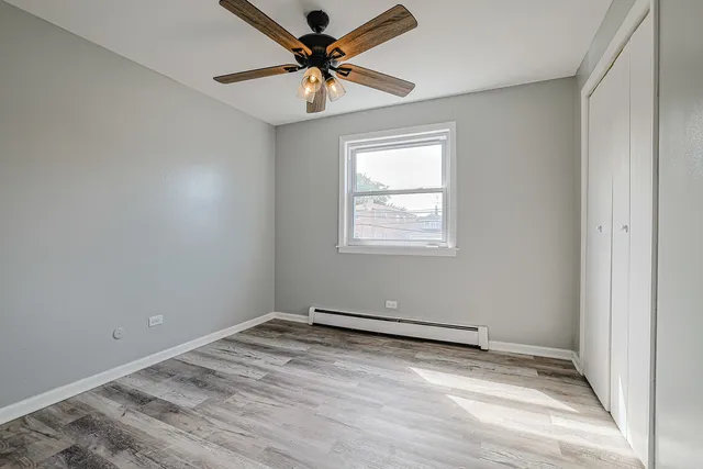 an empty room with a window and a fan