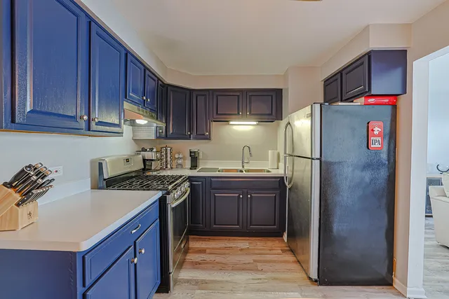 a kitchen with stainless steel appliances granite countertop a refrigerator a stove and a sink