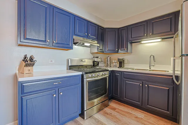 a kitchen with stainless steel appliances granite countertop a sink stove and cabinets
